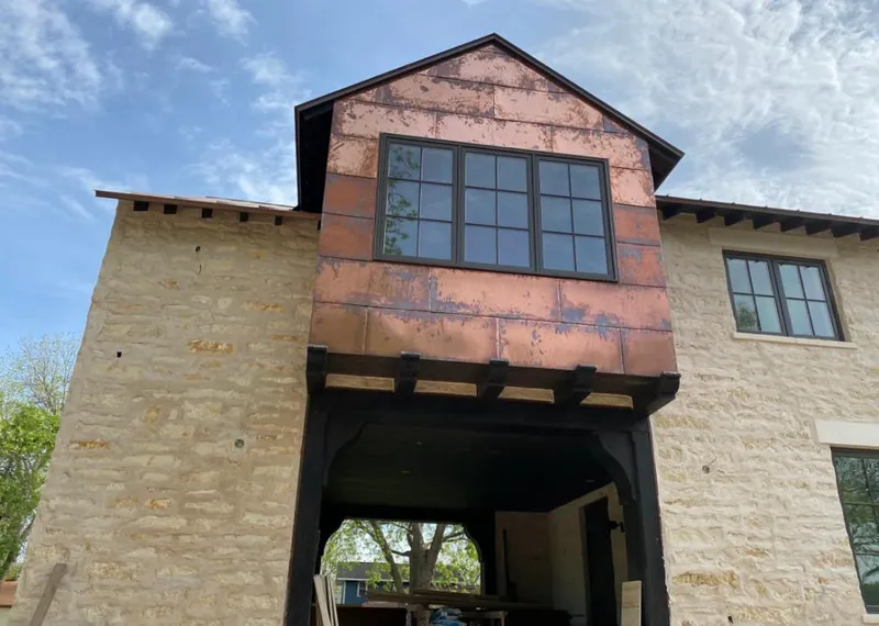 Copper metal panel facade on a stone building for Skylight Installation in Round Lake